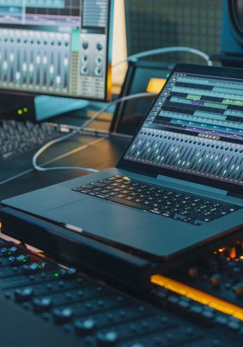Modern Music Record Studio Control Desk with Laptop Screen Showi Modern Music Record Studio Control Desk with Laptop Screen Showing User Interface of Digital Audio Workstation Software. Equalizer, Mixer and Professional Equipment. Faders, Sliders. Record. Close-up